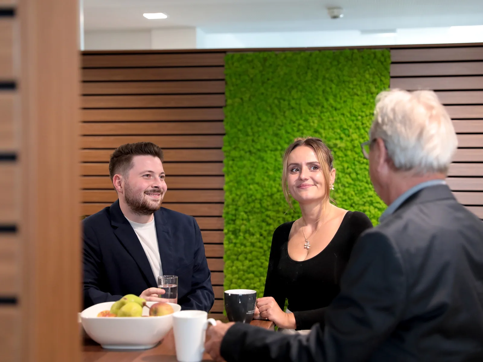Akustisch wirksame Holzlamellen- und Mooswand im Büro von Makowka & Hanik