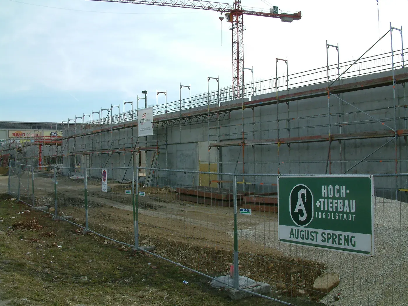 Langgestreckte Betonfertigteilwand des Rohbaus mit vorgestelltem Gerü - Ingenieurbüro Makowka & Hanik Langgestreckte Betonfertigteilwand des Rohbaus mit vorgestelltem Gerüst und Baukran im Hintergrund